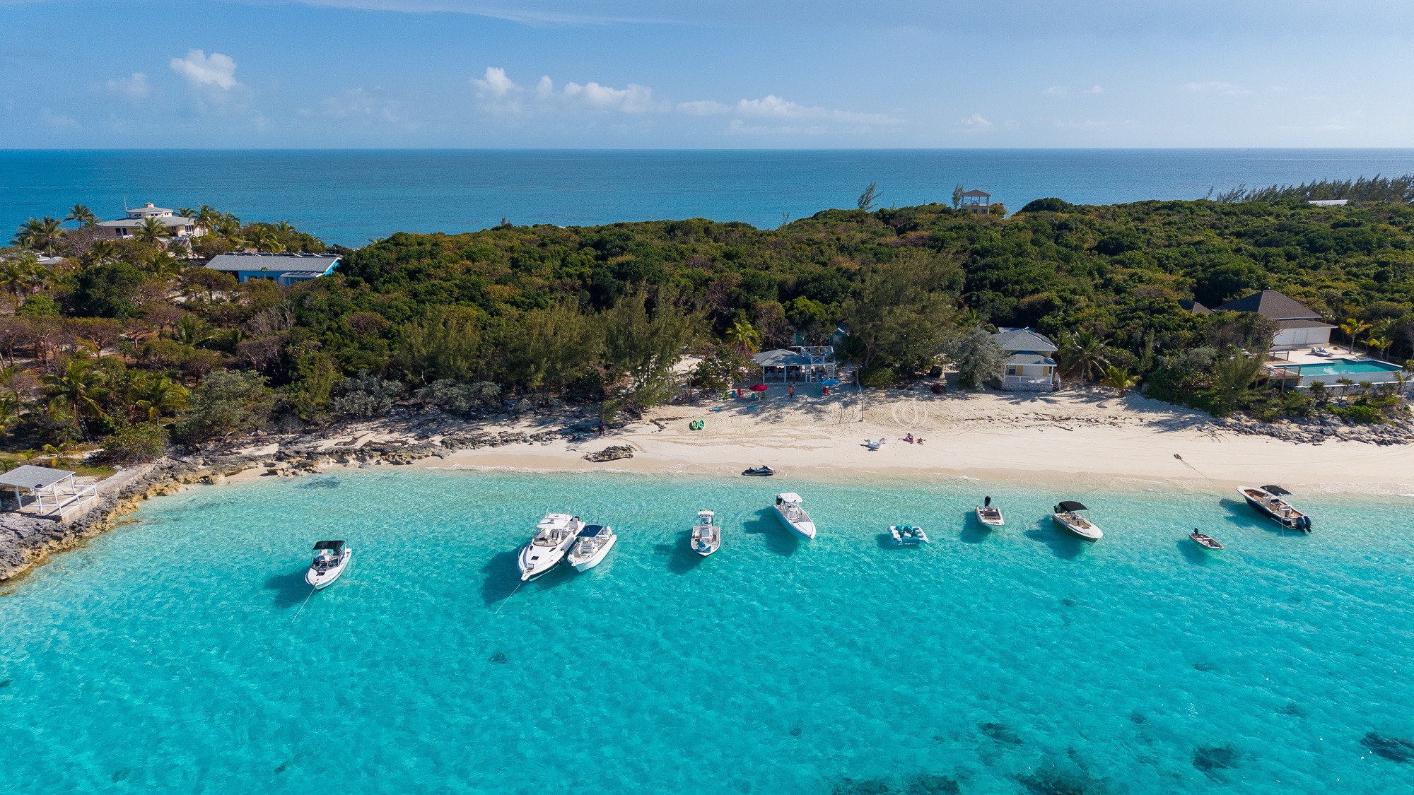 Aerial view of Monkey Business Beach Bar on Rose Island Bahamas with boats anchored in turquoise water